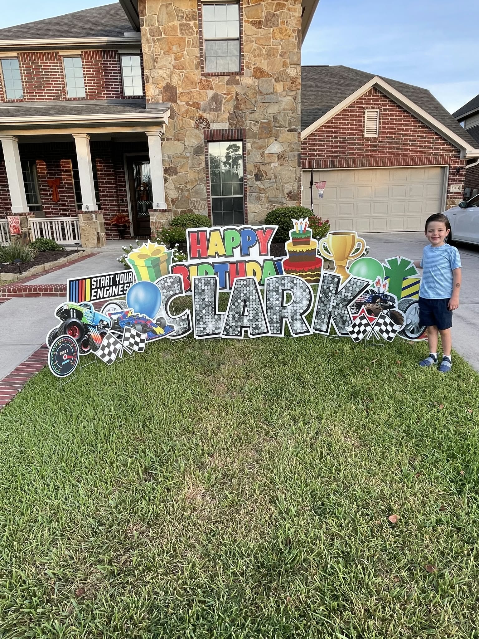 Child posing with Happy Birthday yard sign